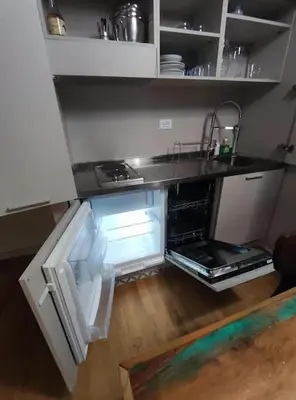 a kitchen with an open refrigerator and a sink at 150 m dal Colosseo - Appartamento Minerva in Rome