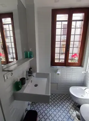 a white bathroom with a sink and a toilet at 150 m dal Colosseo - Appartamento Minerva in Rome