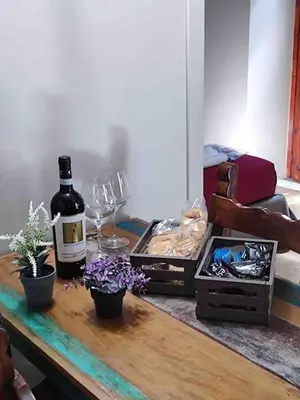 a table with a bottle of wine and glasses on it at 150 m dal Colosseo - Appartamento Minerva in Rome