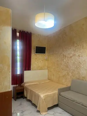 a small bedroom with a bed and a couch at Termini Golden house in Rome