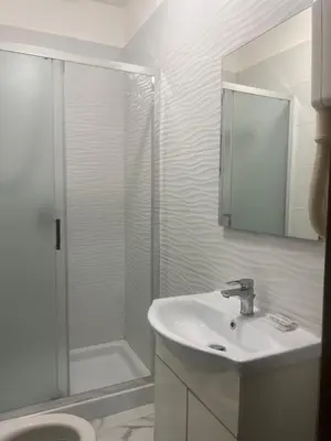 a white bathroom with a sink and a shower at Termini Golden house in Rome