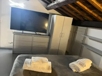 a bedroom with a tv and two towels on a table at Vatican near Sweet Home Terrace in Rome