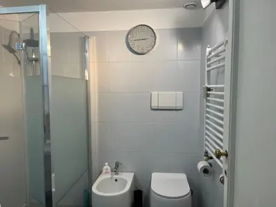 a bathroom with a toilet and a clock on the wall at Vatican near Sweet Home Terrace in Rome