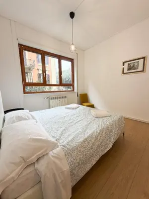 a white bedroom with a bed and a window at Mazzini Boutique Apartment in Rome