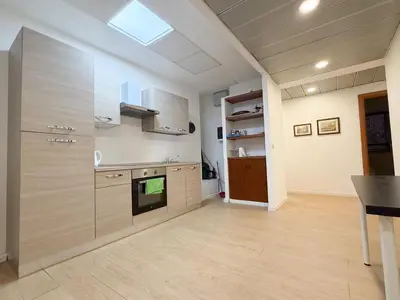 a kitchen with wooden cabinets and a stove top oven at Mazzini Boutique Apartment in Rome
