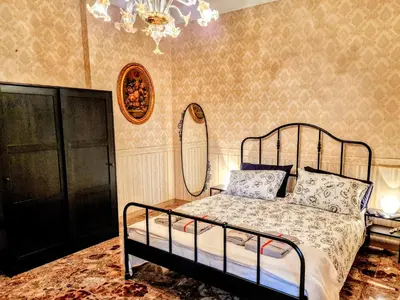 a bedroom with a bed and a mirror and a chandelier at Grazia Guesthouse in Rome