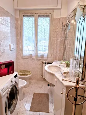 a bathroom with a sink and a washing machine at Grazia Guesthouse in Rome
