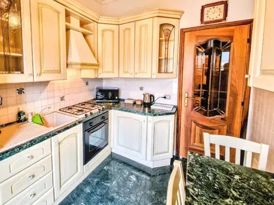 a kitchen with white cabinets and marble counter tops at Grazia Guesthouse in Rome