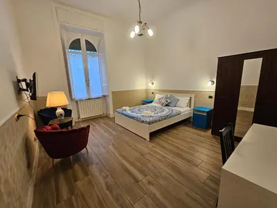 a bedroom with a bed and a chair in a room at 4rooms In Rome in Rome