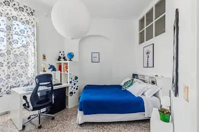 a bed with white pillows and a picture of a giraffe at Bright Vatican Suite - Garden View Balcony & Full Kitchen in Rome