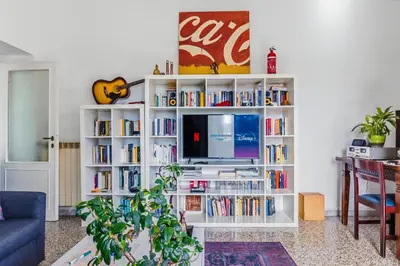 a living room with a blue couch and a table at Bright Vatican Suite - Garden View Balcony & Full Kitchen in Rome