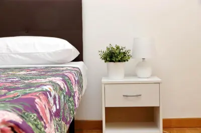 a bedroom with a bed and a nightstand with a plant at Sanctuary Home 32 in Rome