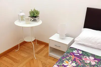 a bedroom with a bed and a night stand with a plant at Sanctuary Home 32 in Rome