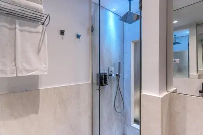 a bathroom with a shower with a glass door at Telier Tomacelli in Rome