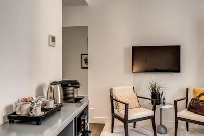 a living room with two chairs and a television on the wall at Telier Tomacelli in Rome