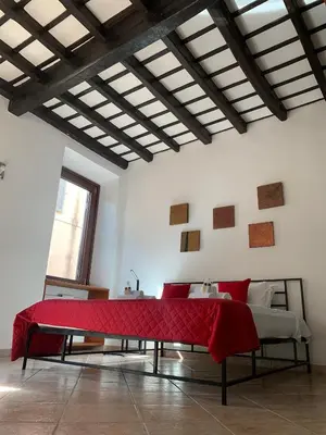 a room with a table with a red blanket on it at Mc - Trastevere in Rome