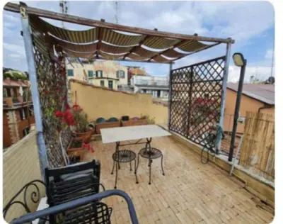 a patio with a table and chairs on a balcony at La Rosa di piazza Spagna in Rome