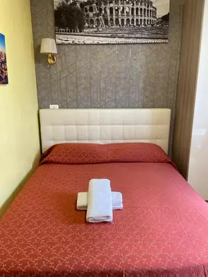 a bedroom with a red bed with two towels on it at Mille Guest HOUSE in Rome