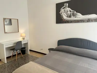 a bedroom with a bed and a desk with a statue at House of Mia in Prati in Rome