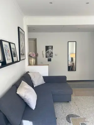 a living room with a blue couch and some pictures at House of Mia in Prati in Rome