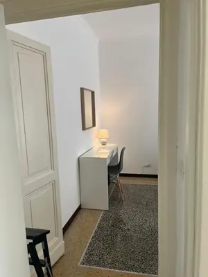 a room with a desk with a chair and a lamp at House of Mia in Prati in Rome