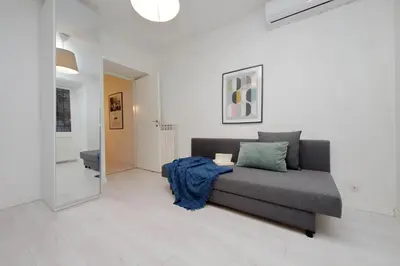 a living room with a gray couch and a mirror at Monti Spacious Apartment 2 in Rome