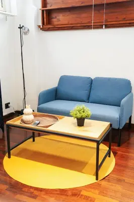a living room with a blue couch and a coffee table at babuino terrace in Rome