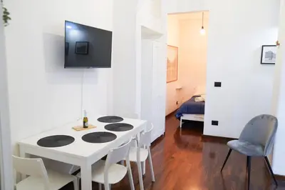 a kitchen with a white table and chairs and a room at babuino terrace in Rome