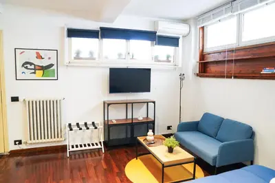 a living room with a blue couch and a tv at babuino terrace in Rome
