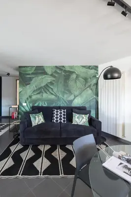 a living room with a black couch and a mural at Loft 36 by Nosdom Properties in Rome