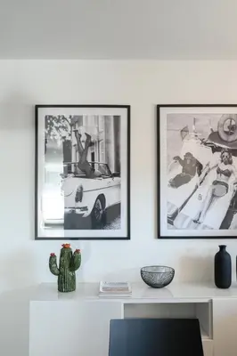 two framed photographs of a car on a white wall at Loft 36 by Nosdom Properties in Rome