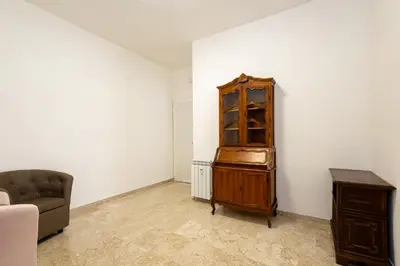 a living room with a wooden cabinet and a chair at Jmartins Vatican 2 in Rome