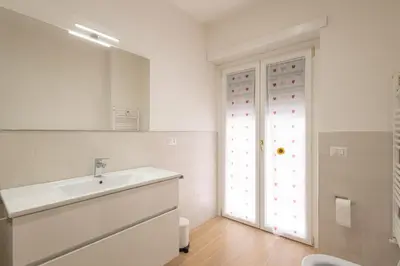 a white bathroom with a sink and a window at Jmartins Vatican 2 in Rome
