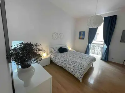 a bedroom with a bed and a table with a plant at Domus Roma Esquilino in Rome