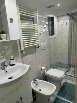 a white bathroom with a sink and a toilet at Domus Roma Esquilino in Rome