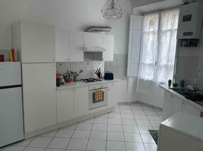 a kitchen with white cabinets and a stove top oven at Domus Roma Esquilino in Rome