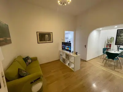 a living room with a green couch and a television at Domus Roma Esquilino in Rome