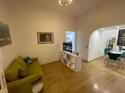 a living room with a green couch and a television at Domus Roma Esquilino in Rome