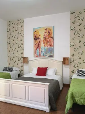 a bedroom with two beds and a painting on the wall at House Villa Fiorelli in Rome