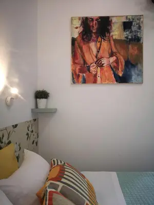 a painting of a woman on a wall next to a bed at House Villa Fiorelli in Rome