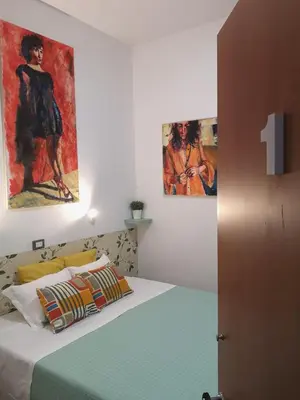 a bedroom with a bed and two paintings on the wall at House Villa Fiorelli in Rome