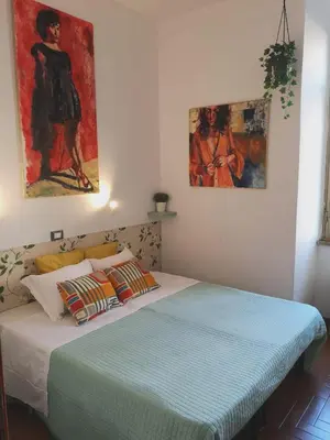 a bedroom with two beds and two paintings on the wall at House Villa Fiorelli in Rome