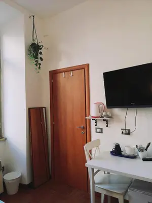 a room with a wooden door and a table and a tv at House Villa Fiorelli in Rome