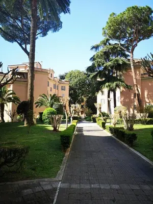 a walkway in front of a building with palm trees at House Villa Fiorelli in Rome