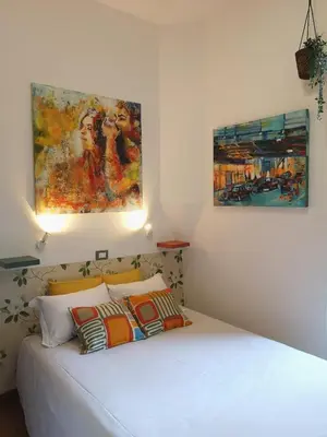 a bedroom with a bed with two paintings on the wall at House Villa Fiorelli in Rome