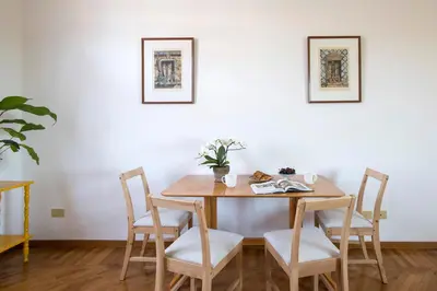 a dining room table and chairs with two pictures on the wall at Refined upper-level apartment - Unique View of Rome's Skyline Tibernestrome in Rome