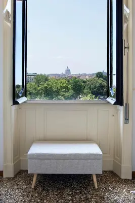 a bench sitting in front of a window at Refined upper-level apartment - Unique View of Rome's Skyline Tibernestrome in Rome