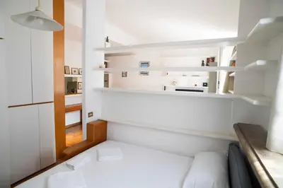 a small room with white shelves and a couch at Tamara e Gerardina House in Trastevere in Rome