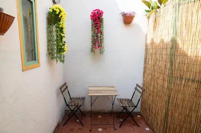 a table and chairs on a patio with flowers at Tamara e Gerardina House in Trastevere in Rome