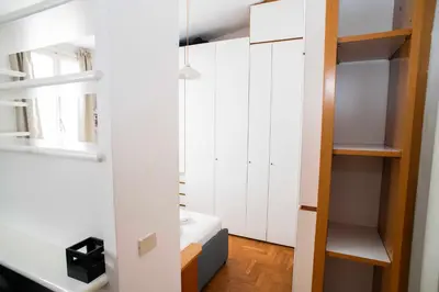 a small apartment with white cabinets and a bed in a room at Tamara e Gerardina House in Trastevere in Rome